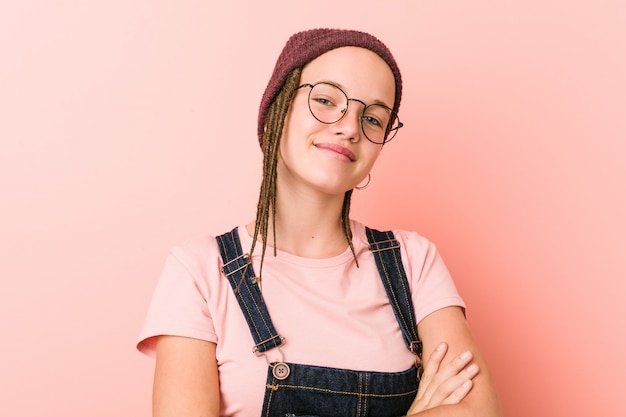 Het jonge Kaukasische hipstervrouw glimlachen zeker met gekruiste wapens