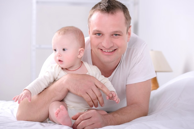 Het jonge Kaukasische vader spelen met babyzoon thuis.