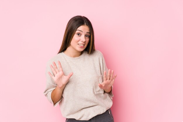 Het jonge kaukasische vrouw geïsoleerd stellen verwerpend iemand die een gebaar van afschuw tonen.