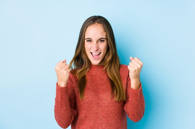 Het jonge Kaukasische vrouw stellen geïsoleerd onbezorgd en opgewekt toejuichen. Overwinning concept.