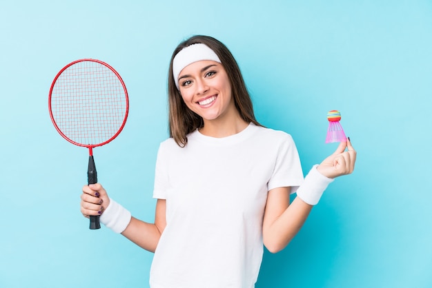 Het jonge Kaukasische vrouwen speelbadminton isoleerde gelukkig, glimlachend en vrolijk.