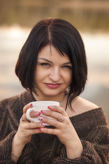 Het jonge meisje drinkt koffie in openlucht emoties