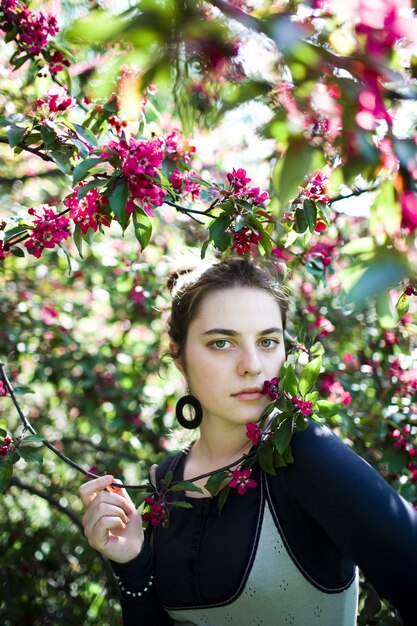 Het jonge meisje genieten van van de tot bloei komende geur van boombloemen.