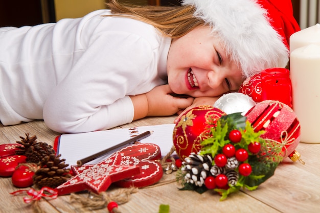 Het jonge meisje in Kerstmishoed schrijft brief aan Santa Claus