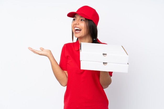 Het jonge meisje van de Pizzalevering over geïsoleerde witte muur met verrassingsgelaatsuitdrukking
