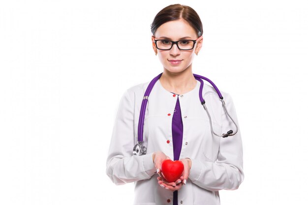 Het jonge mooie vrouwelijke hart van de artsenholding in haar handen op witte achtergrond