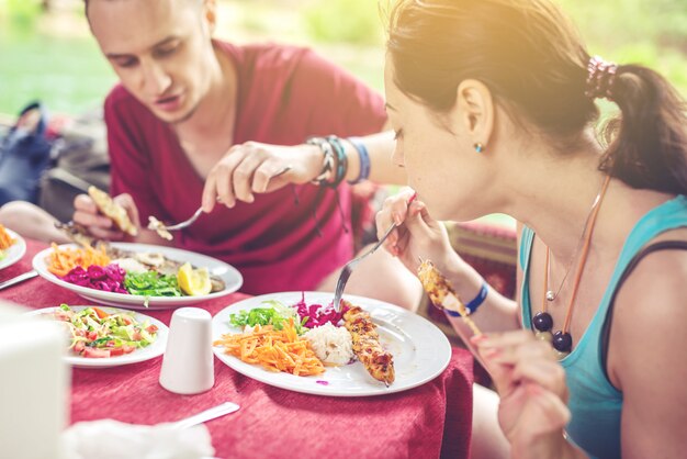 Foto het jonge paar eet in openlucht groenten en vissen