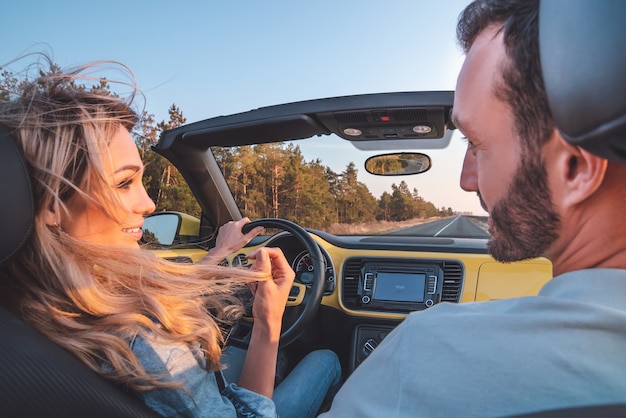 Het jonge stel dat in een cabriolet reist