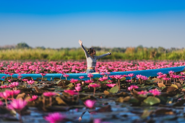 Het jonge vrouw ontspannen met het mooie gebied van de lotusbloembloem bij het Rode Lotus-Overzees