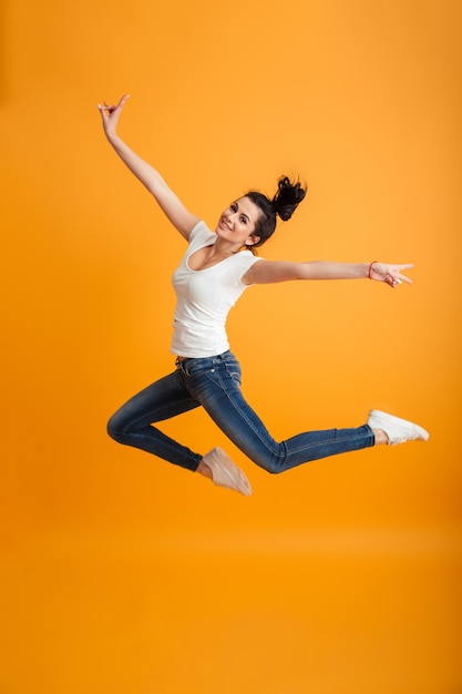 Het jonge vrouw springen maakt vredesgebaar.