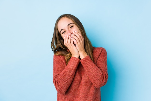 Het jonge vrouw stellen die over iets lachen, die mond behandelen met handen.