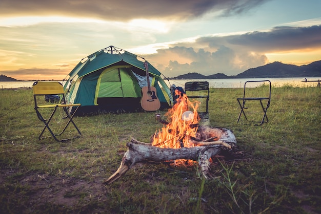 Het kamperen tent met vuur in de groene gebiedsweide