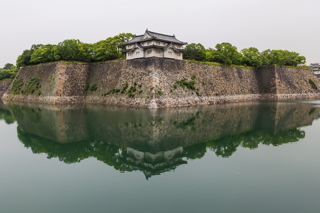 Het kasteelmuren die van osaka in water nadenken