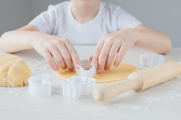 Het kind bereidt zelfgemaakte kerstkoekjes