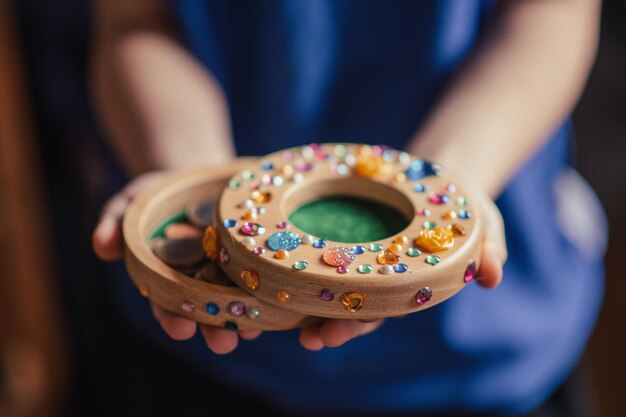 Het kind bespaart geld Kinderspaarvarken versierd met strass-steentjes in de handen