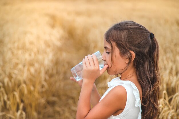 Het kind drinkt water uit een glas. Selectieve aandacht.