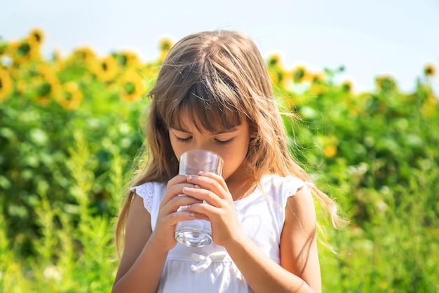 Het kind drinkt water uit een glas. Selectieve aandacht.