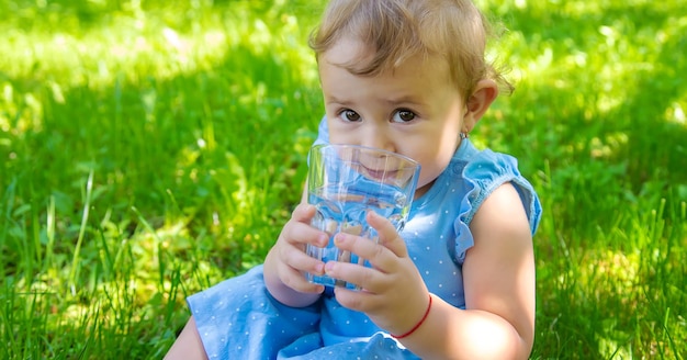 Foto het kind drinkt water uit een glas selectieve focus