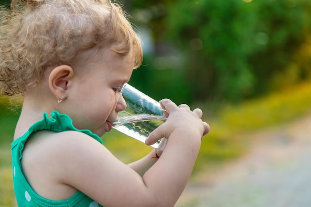 Het kind drinkt water uit een glas Selectieve focus