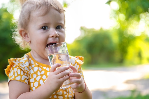 Het kind drinkt water uit een glas Selectieve focus