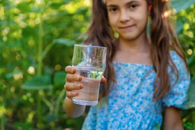 Het kind drinkt water uit een glas Selectieve focus