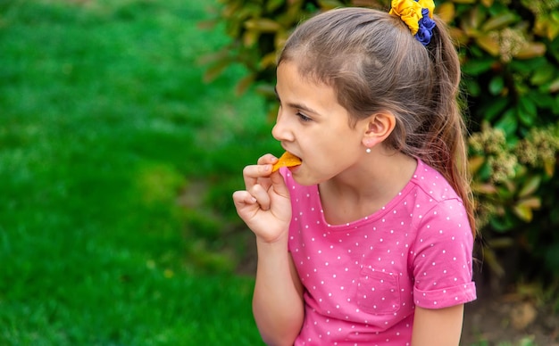 Het kind eet chips in het park Selectieve aandacht