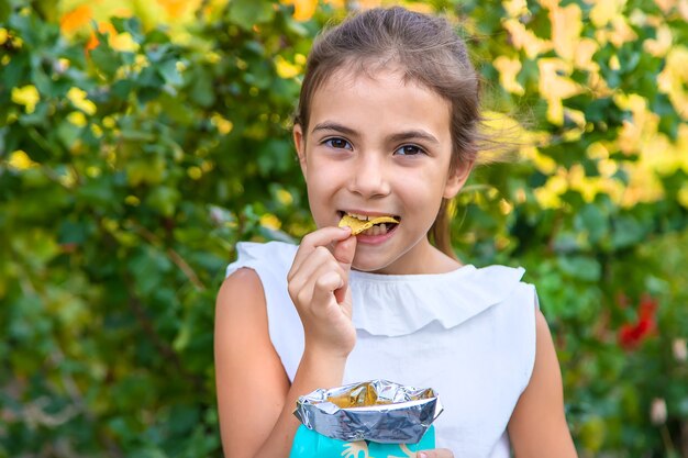 Het kind eet chips. Selectieve aandacht. Kind.