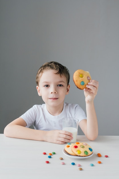 Het kind eet graag zelfgemaakte koekjes met melk