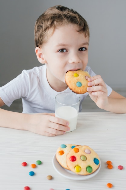 Het kind eet graag zelfgemaakte koekjes met melk