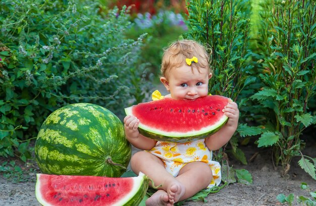 Het kind eet watermeloen in de zomer. Selectieve aandacht. Baby.