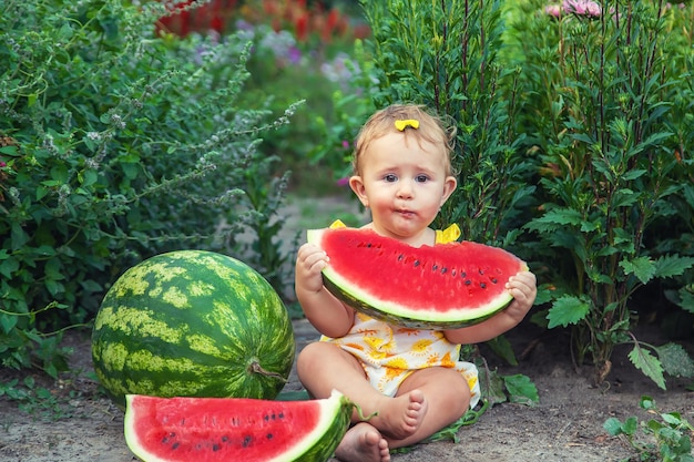 Het kind eet watermeloen in de zomer. Selectieve aandacht. Baby.