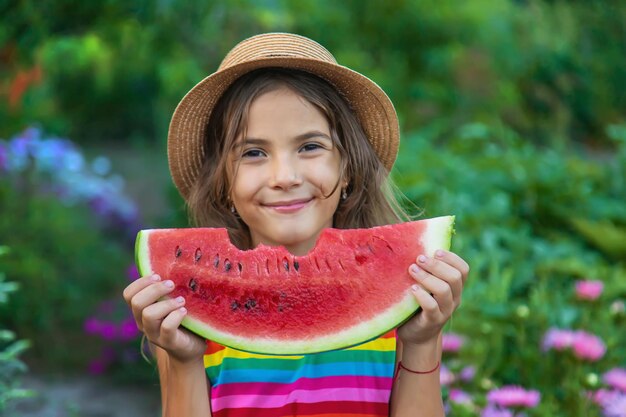 Het kind eet watermeloen in de zomer. Selectieve aandacht.