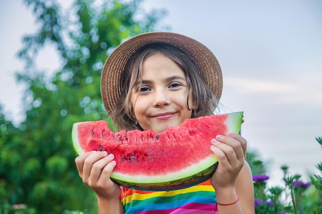 Het kind eet watermeloen in de zomer. Selectieve aandacht.