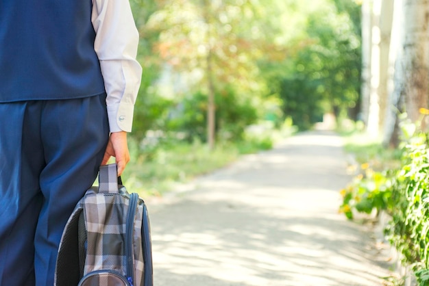 Het kind gaat naar school met een rugzak schooljongen gaat naar school in de ochtend