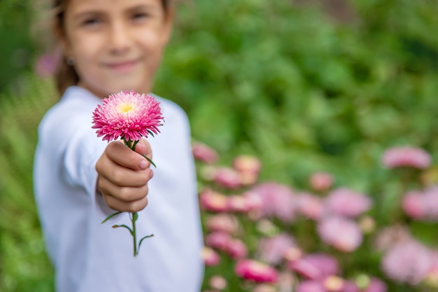 Foto het kind geeft een bloem. selectieve aandacht.