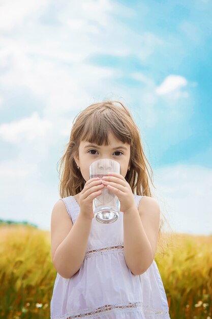 Het kind houdt een glas water in zijn handen. selectieve aandacht.