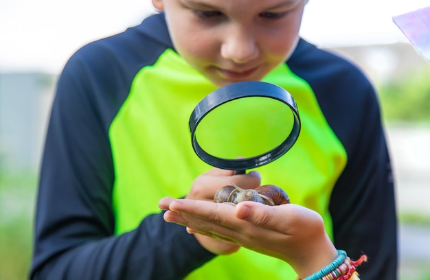 Het kind kijkt naar de slak Selectieve focus