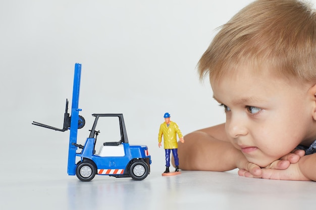 Het kind kijkt naar het werk van bouwmachines het concept van bouwmachines