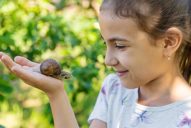 Het kind onderzoekt de slakken op de boom selectieve focus