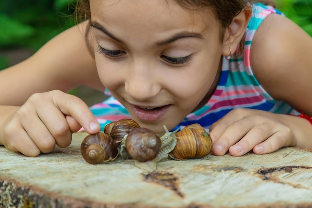 Het kind onderzoekt de slakken op de boom Selectieve focus