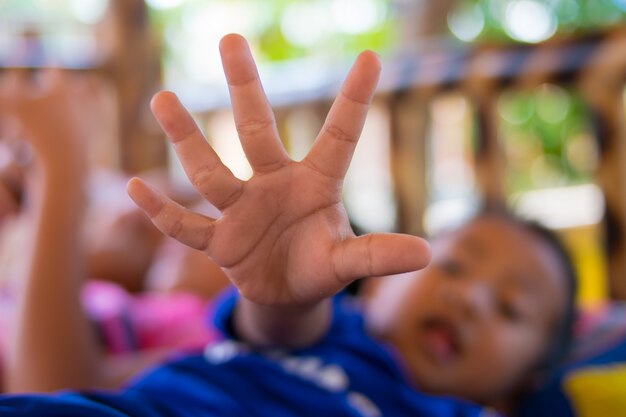 Het kind reikt een hand naar de camera