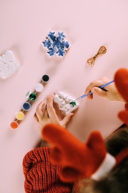 Het kind schildert kerstspeelgoed. bovenaanzicht