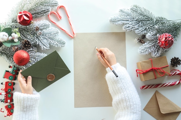 Het kind schrijft een brief aan de Kerstman heeft een envelop in zijn hand sfeervolle nieuwjaarsfoto