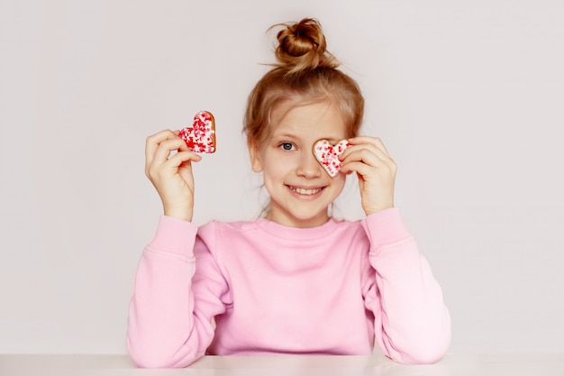 Het kind sluit zijn ogen met koekjes