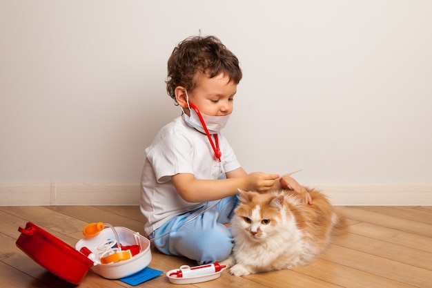 Het kind speelt met het huisdier in de dokter die probeert hem een injectie te geven.