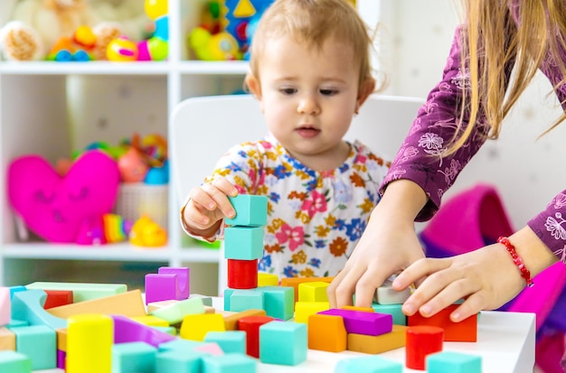 Het kind speelt met speelgoed in de kamer. Selectieve aandacht. Baby.