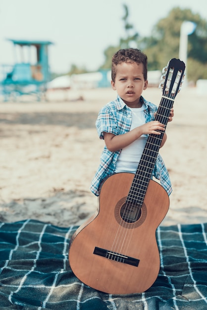 Het kind stelt met akoestische gitaar