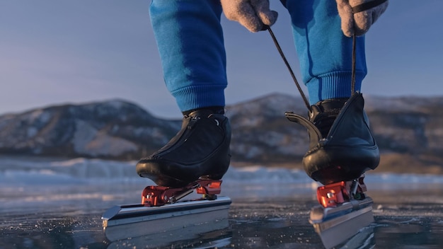 Het kind traint op ijsschaatsen Atleet zet op schaatsen Het meisje schaatst in de winter in sportkleding sportbril Outdoor slow motion