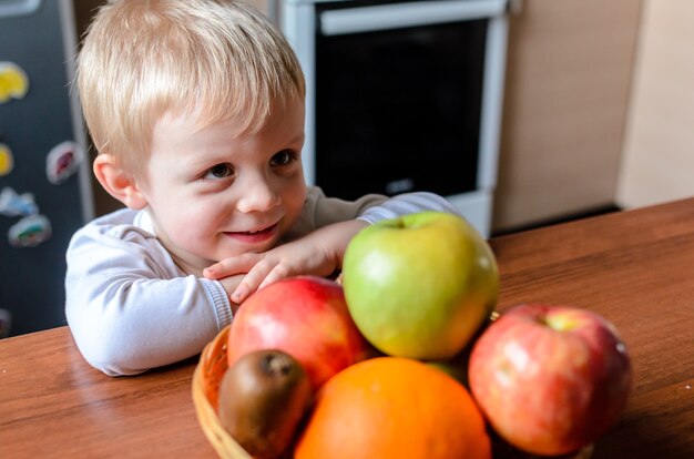 Het kind zoekt fruit en lacht.