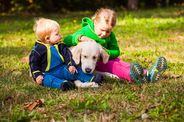 Het kleine broertje en zusje wandelen met hun hond